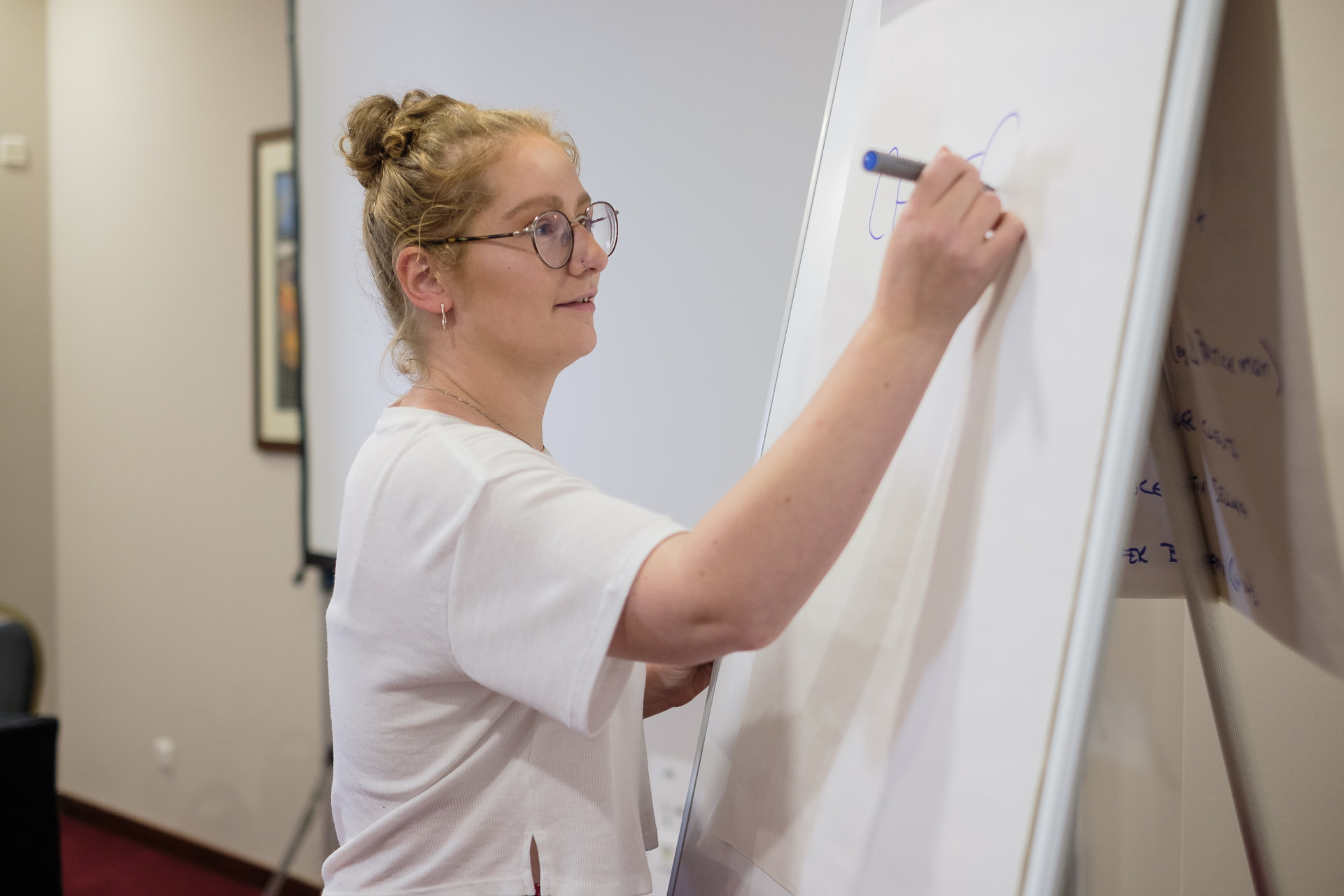 Emily Cross leading a live pricing session at a whiteboard